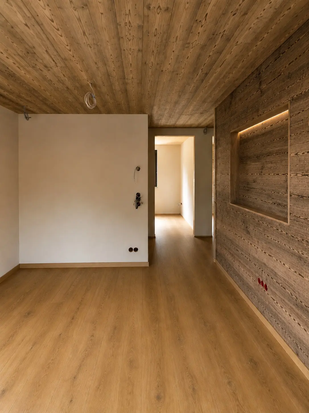 Raum mit Altholz-Decke und Holzboden, Blick in den Flur